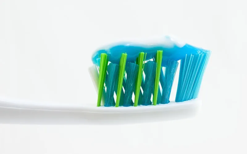 Manual toothbrush with toothpaste ready for brushing as an affordable oral hygiene option