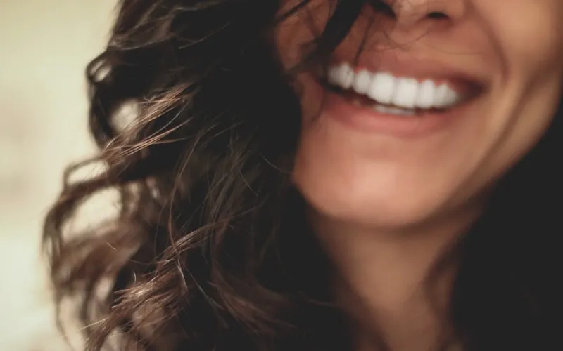 Woman smiling confidently showing healthy teeth protected from acid erosion