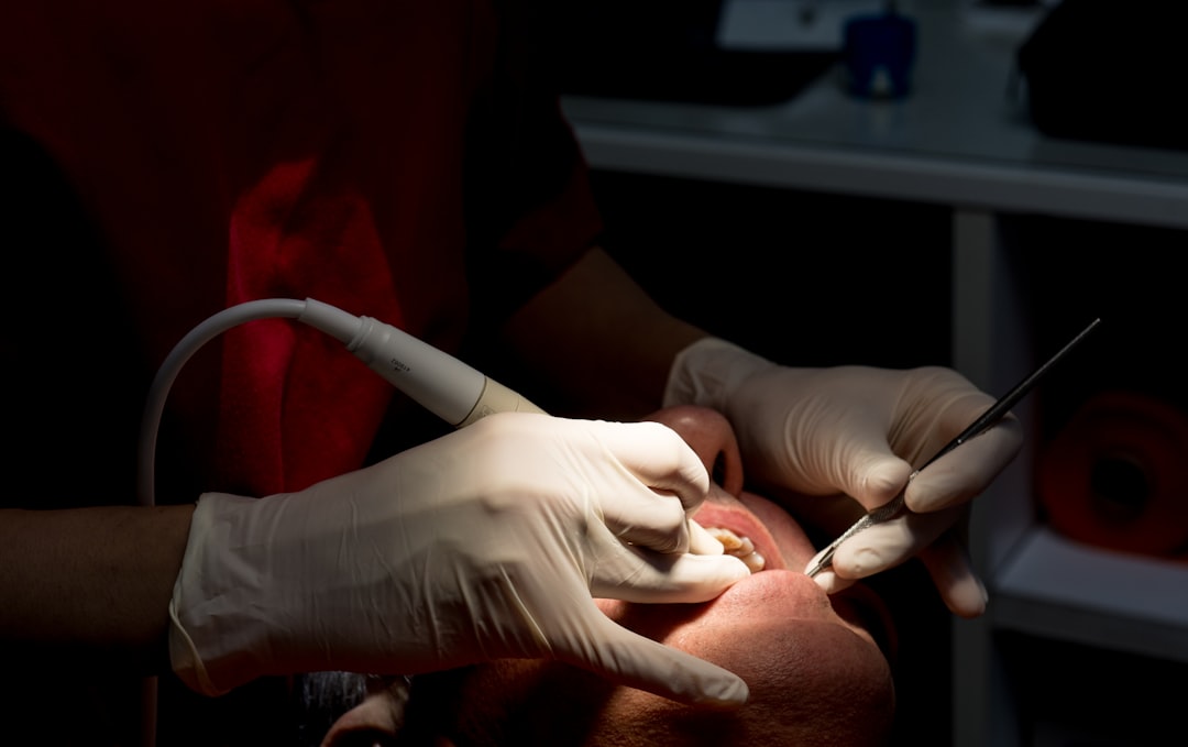 Dentist cleaning patient's teeth with tools