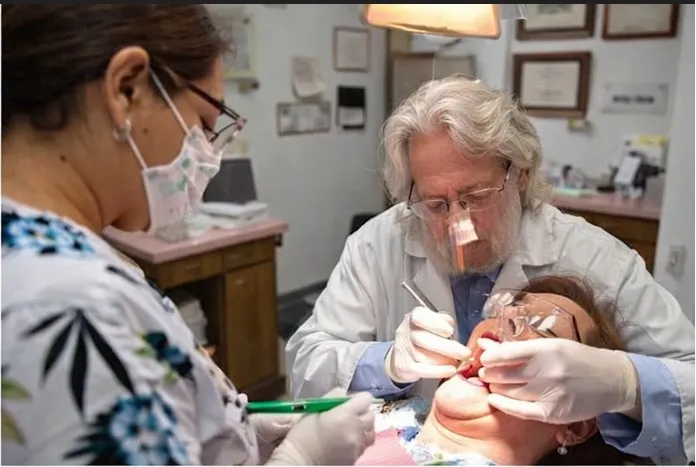 Dr. Baldwin performing a patient dental exam with assistant